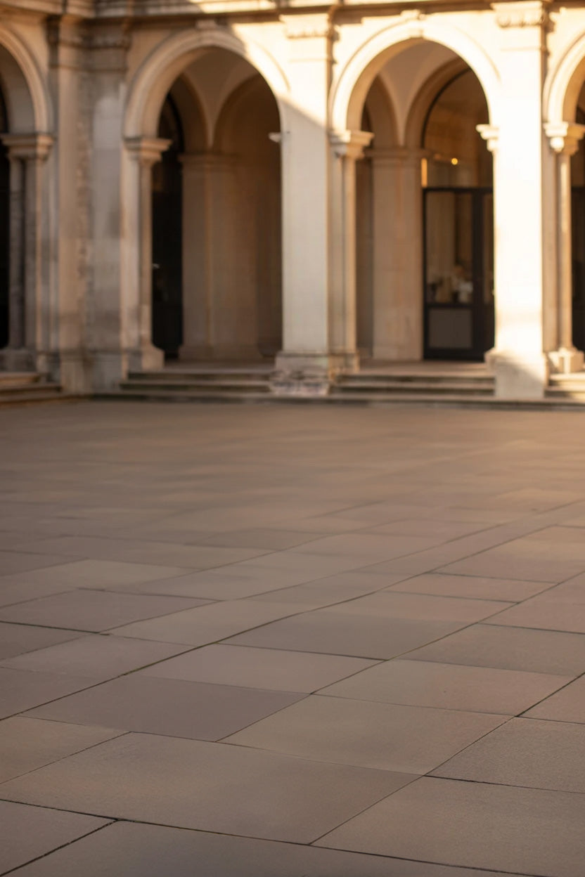 Sunlit stone courtyard with elegant arched architectural columns