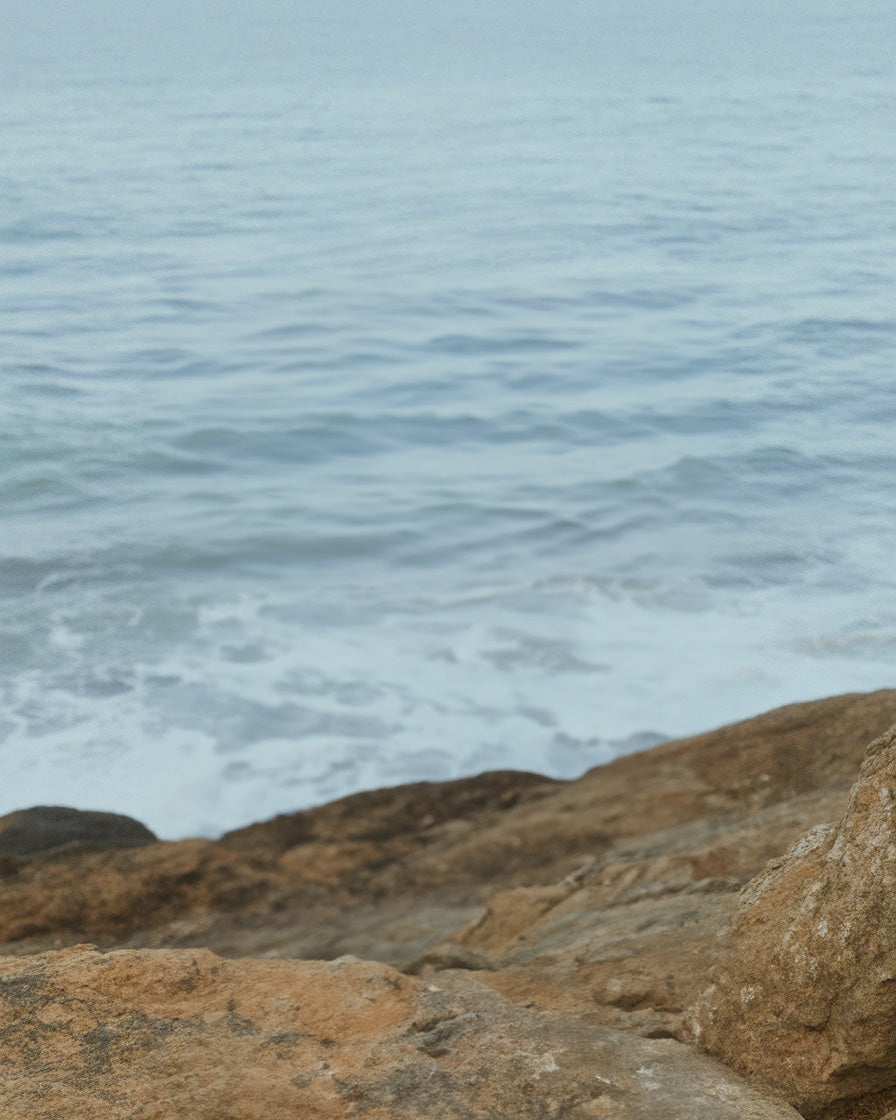 Rocky shoreline with gentle ocean waves and horizon