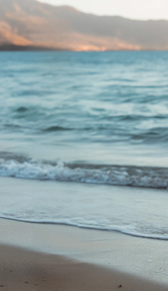 Gentle ocean waves washing onto sandy shoreline view