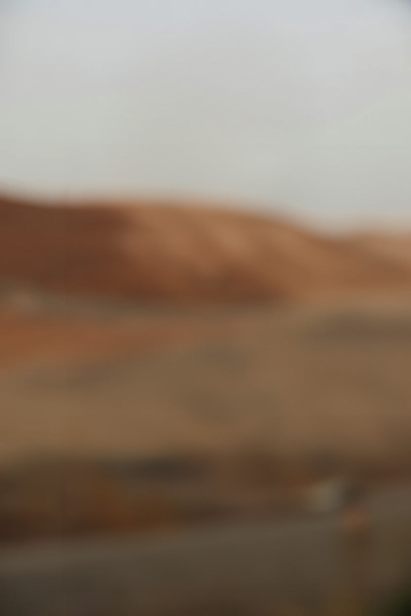Dusty desert landscape with brown hills and cloudy sky