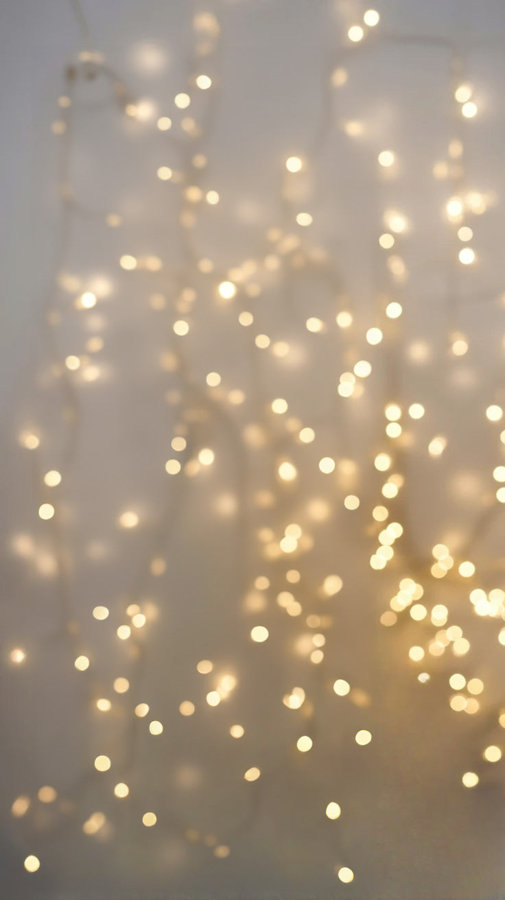 Warm string lights hanging softly against a neutral wall