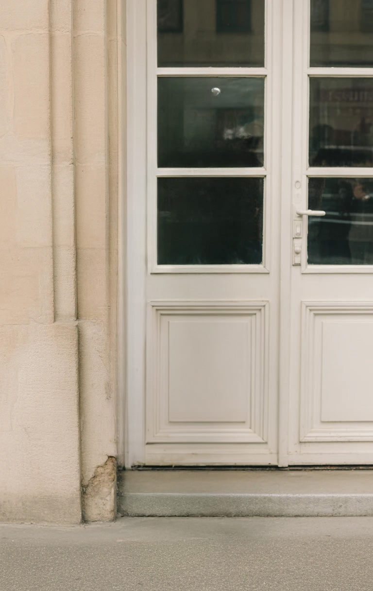 Classic white wooden door with glass panels and stone wall