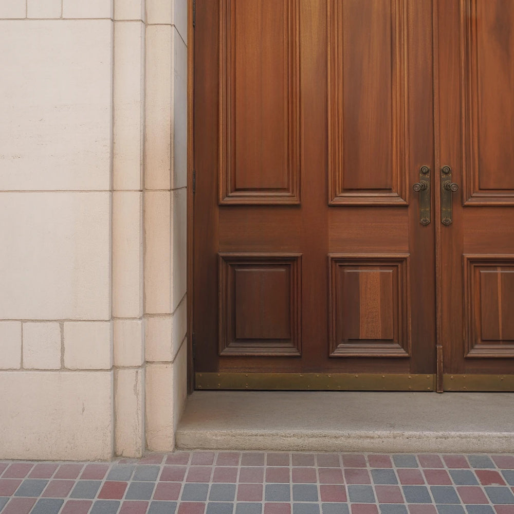 Elegant wooden double doors with stone frame and tiled entryway