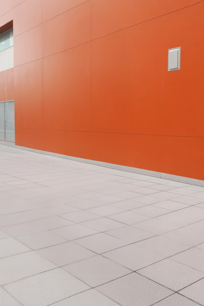 Modern exterior with bright orange wall and tiled walkway