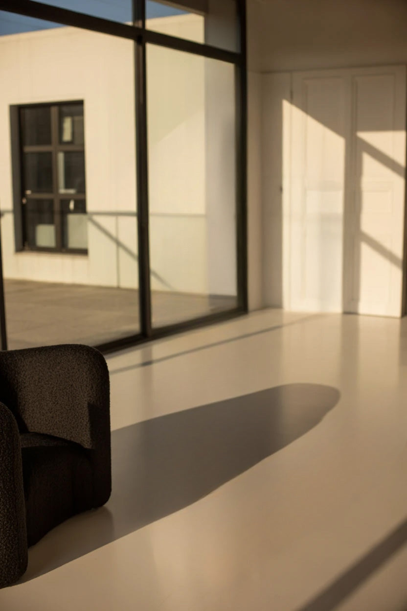 Minimalist room with large windows and sunlight shadows