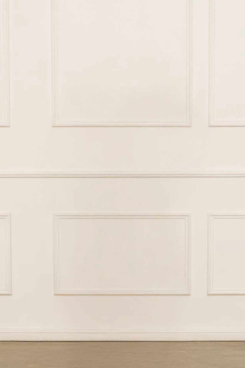 Classic cream wall with decorative molding and plain floor