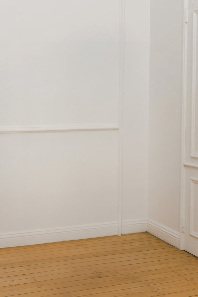 Classic white interior wall with warm wooden plank flooring