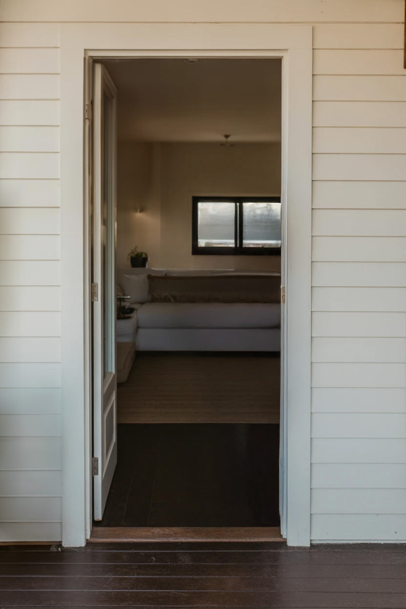 Open doorway leading to cozy interior with sofa and window