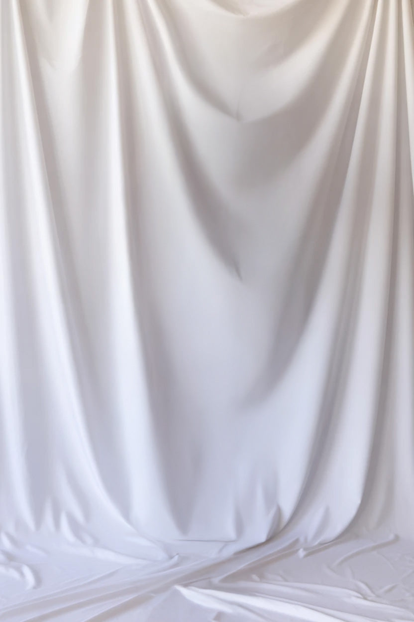 White fabric curtain with soft flowing draped folds