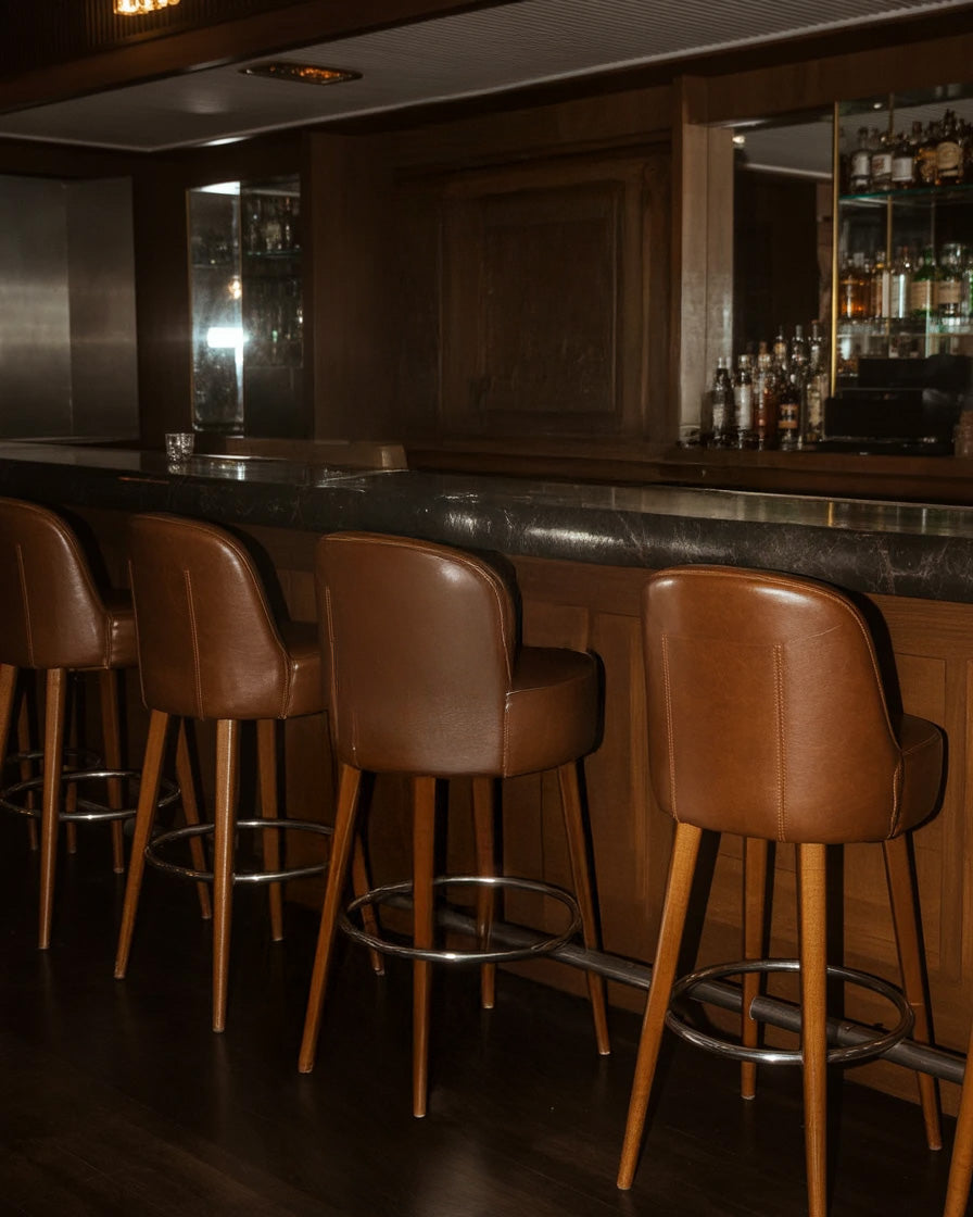 Cozy bar interior with leather stools and dark wooden counter