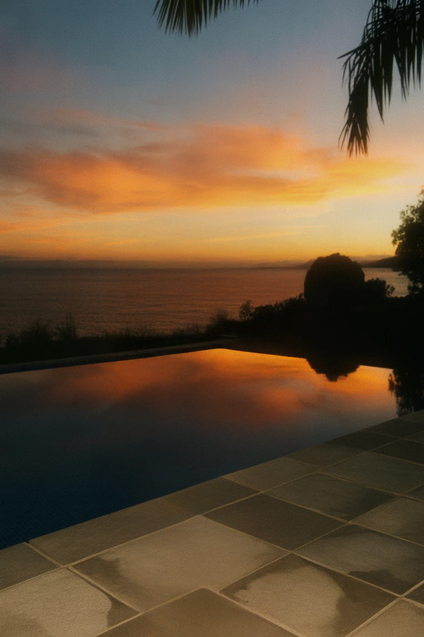 Scenic sunset view over calm ocean with pool reflection