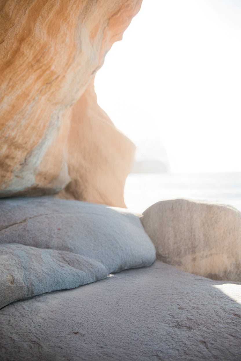 Coastal rock formation with smooth stone surface and bright light