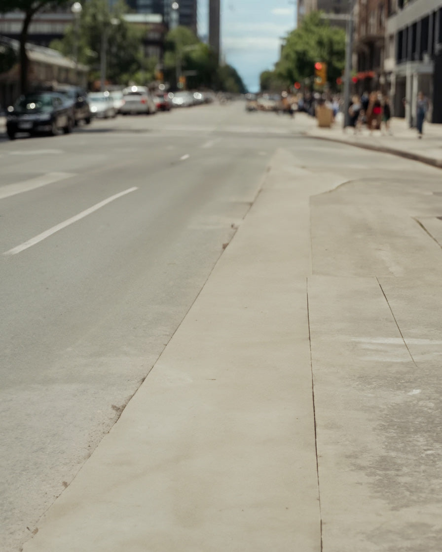 City street with wide sidewalk and distant urban traffic