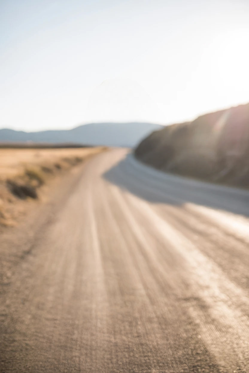 Long winding country road with distant mountain backdrop