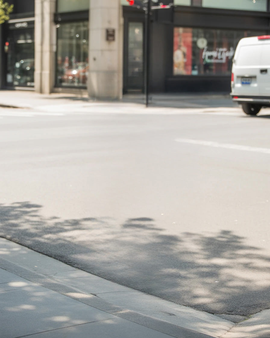 City street corner with modern storefronts and sidewalk shadows