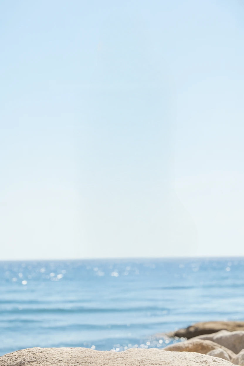 Calm blue ocean horizon with sunlight reflecting off water