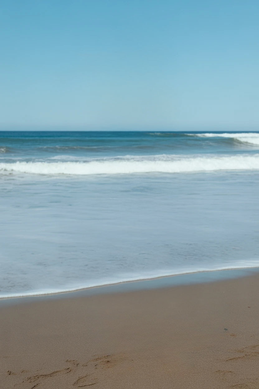 Calm sandy beach with gentle ocean waves and horizon