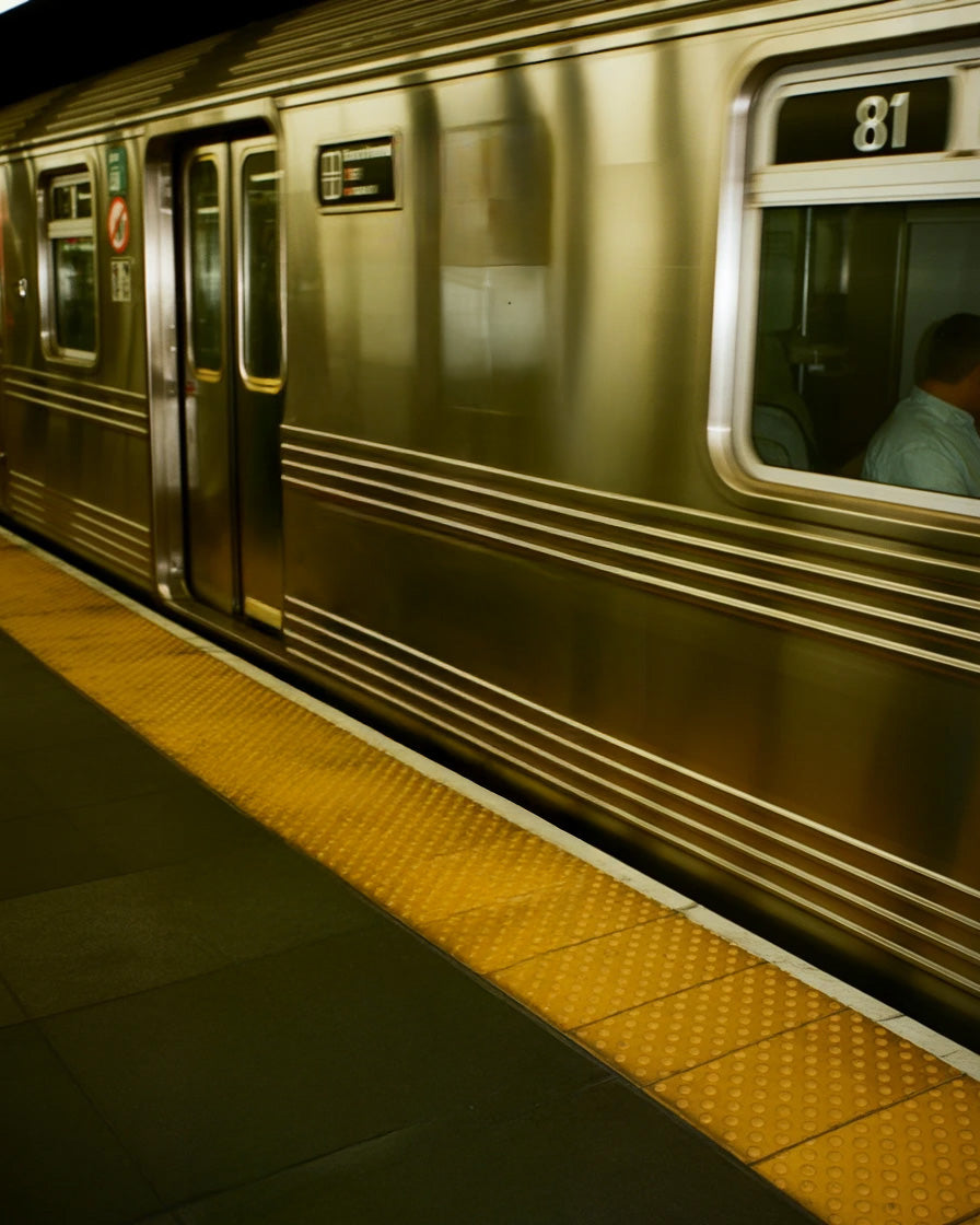 Subway platform with metallic train and yellow tactile paving