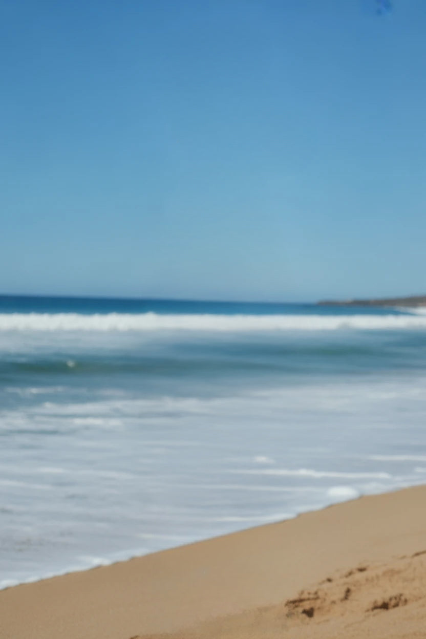 Clear blue sky over gentle waves and sandy beach