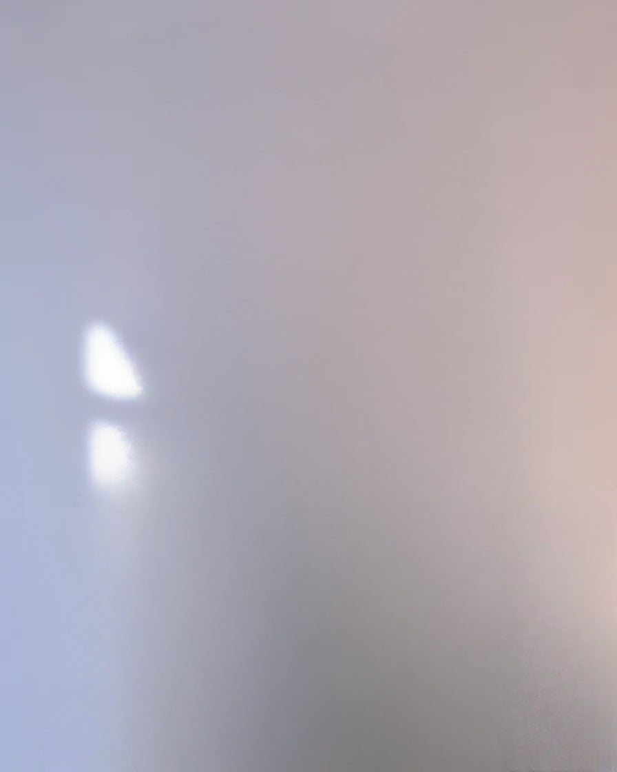 Soft sunlight reflection on a plain pastel wall