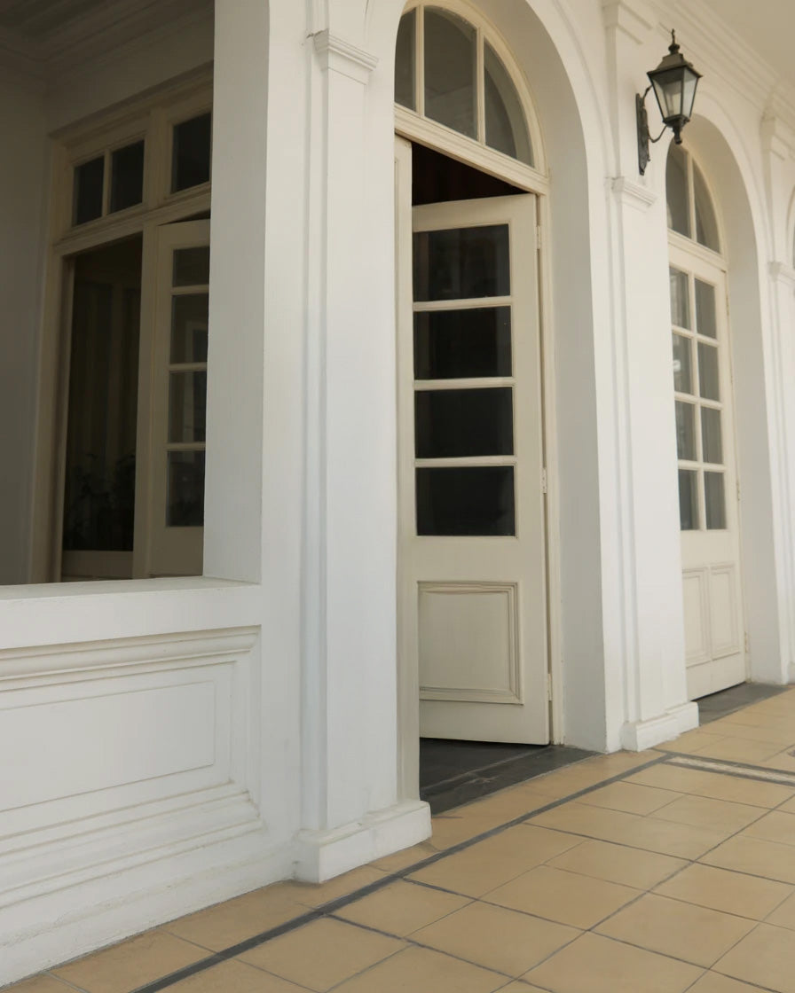Elegant white arched doorway with tiled entrance and lantern light