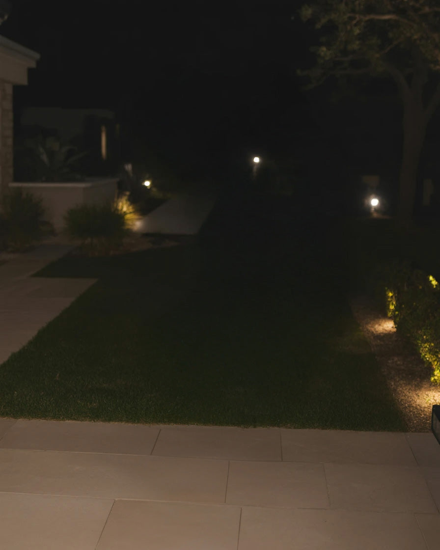 Modern garden pathway with warm ground lighting at night