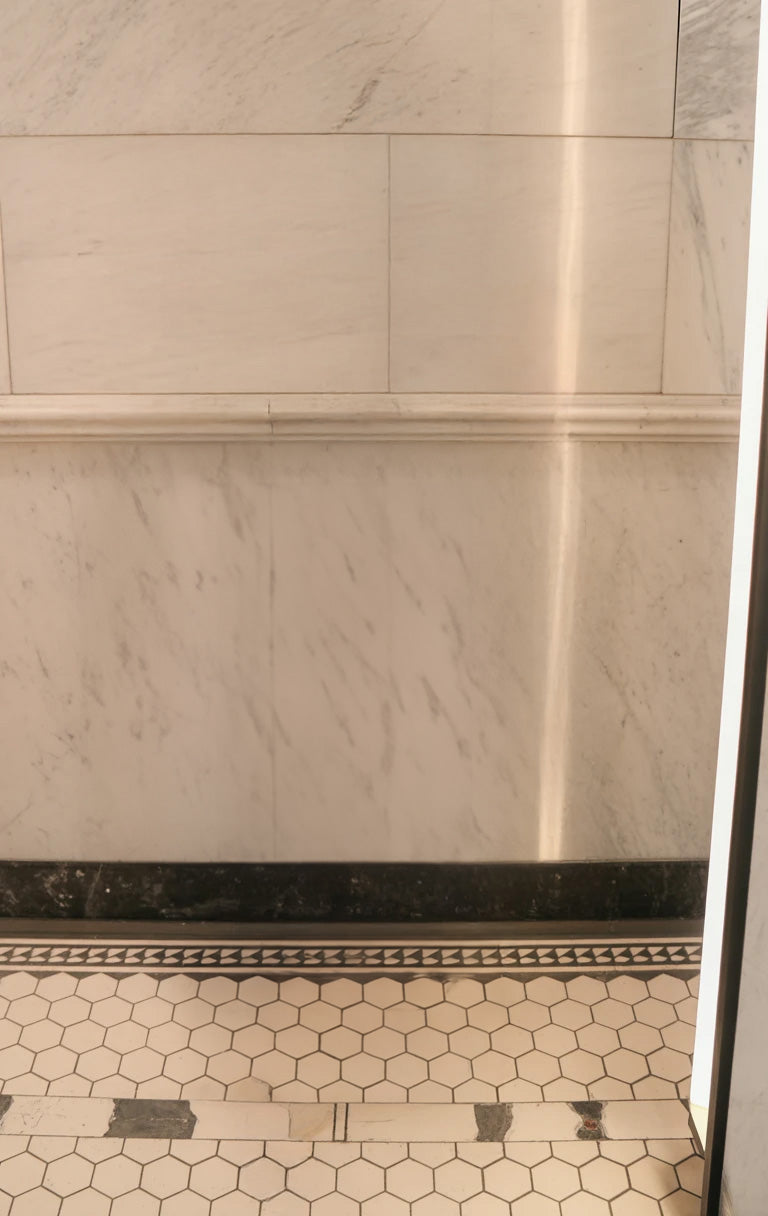 White marble wall with black trim and hexagon tiles