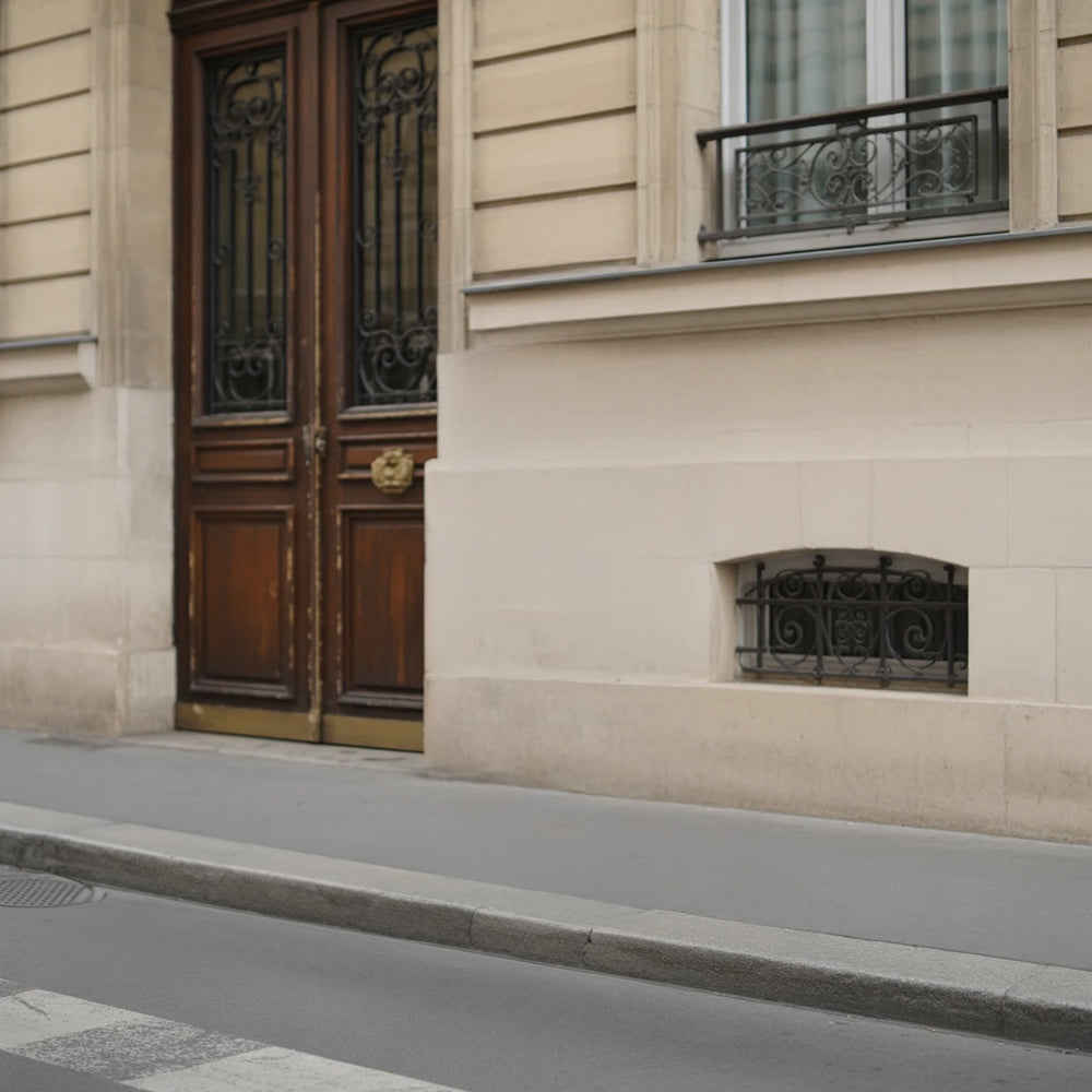 Beige stone building exterior with ornate ironwork and doorway