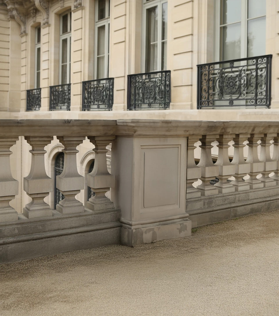 Elegant stone balcony with ornate black wrought iron railings