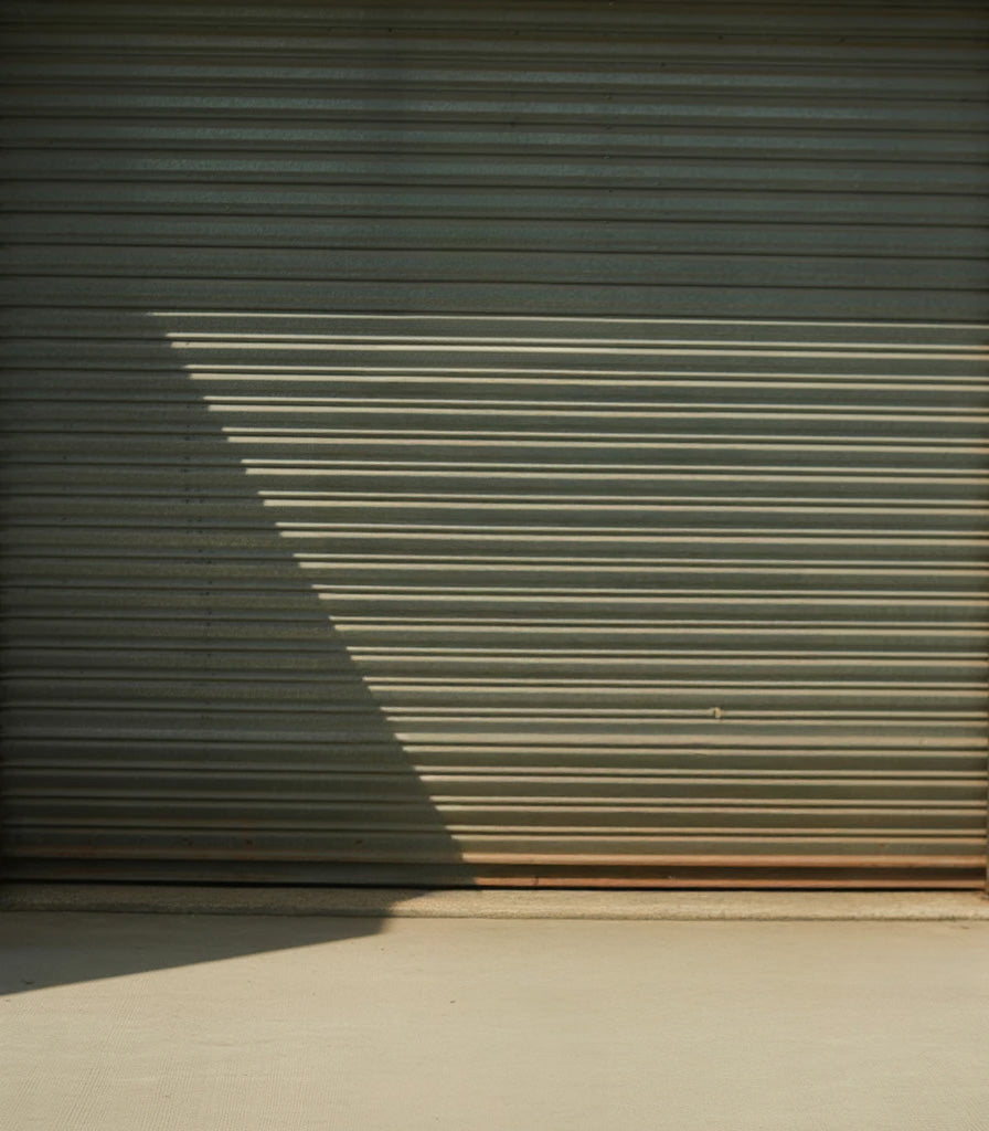 Industrial metal shutter with diagonal sunlight shadow