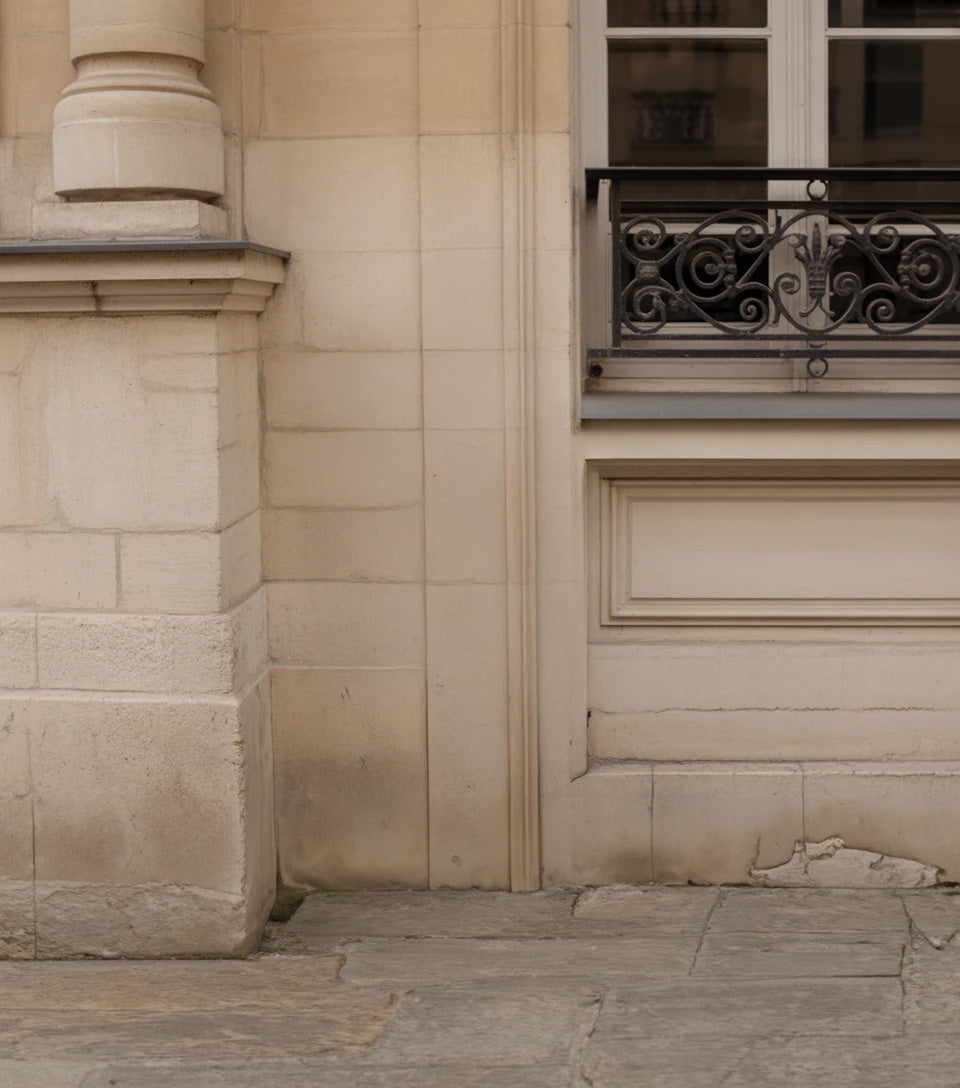 Classic stone building facade with ornate iron window railing