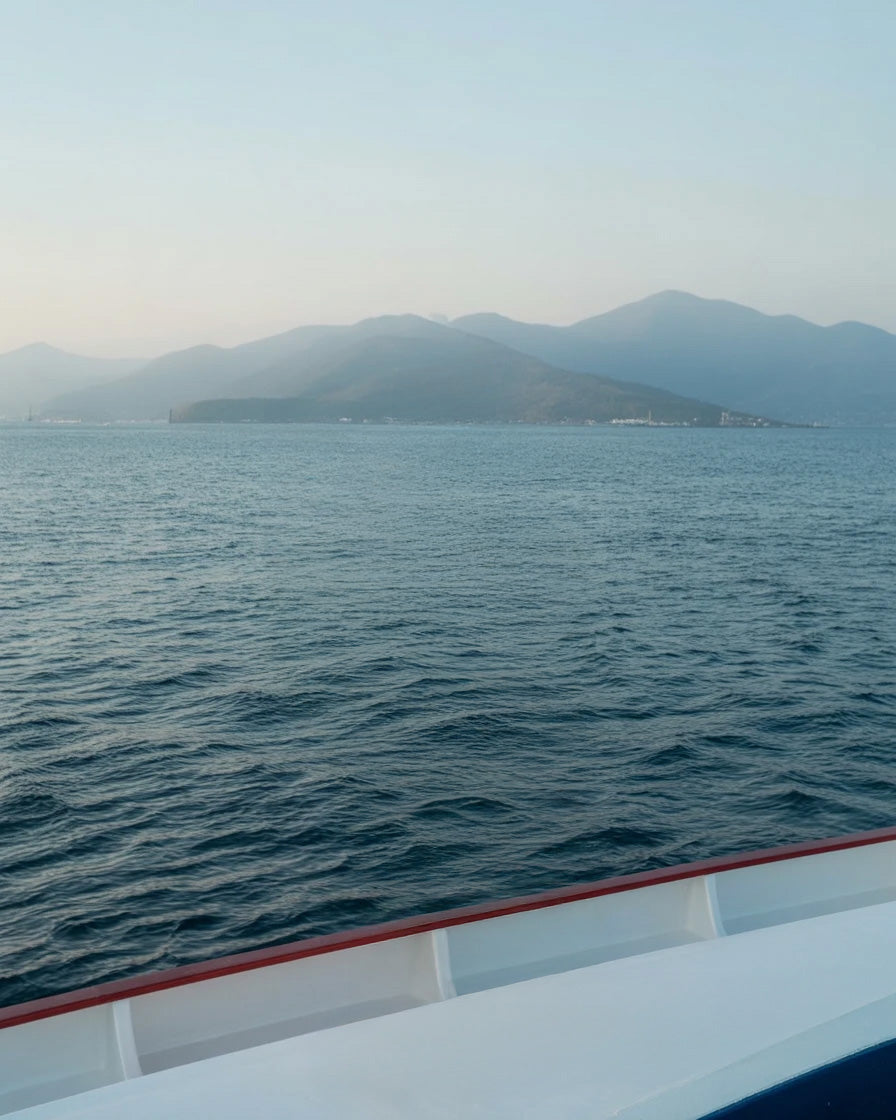 Calm blue sea with distant mountains and hazy sky