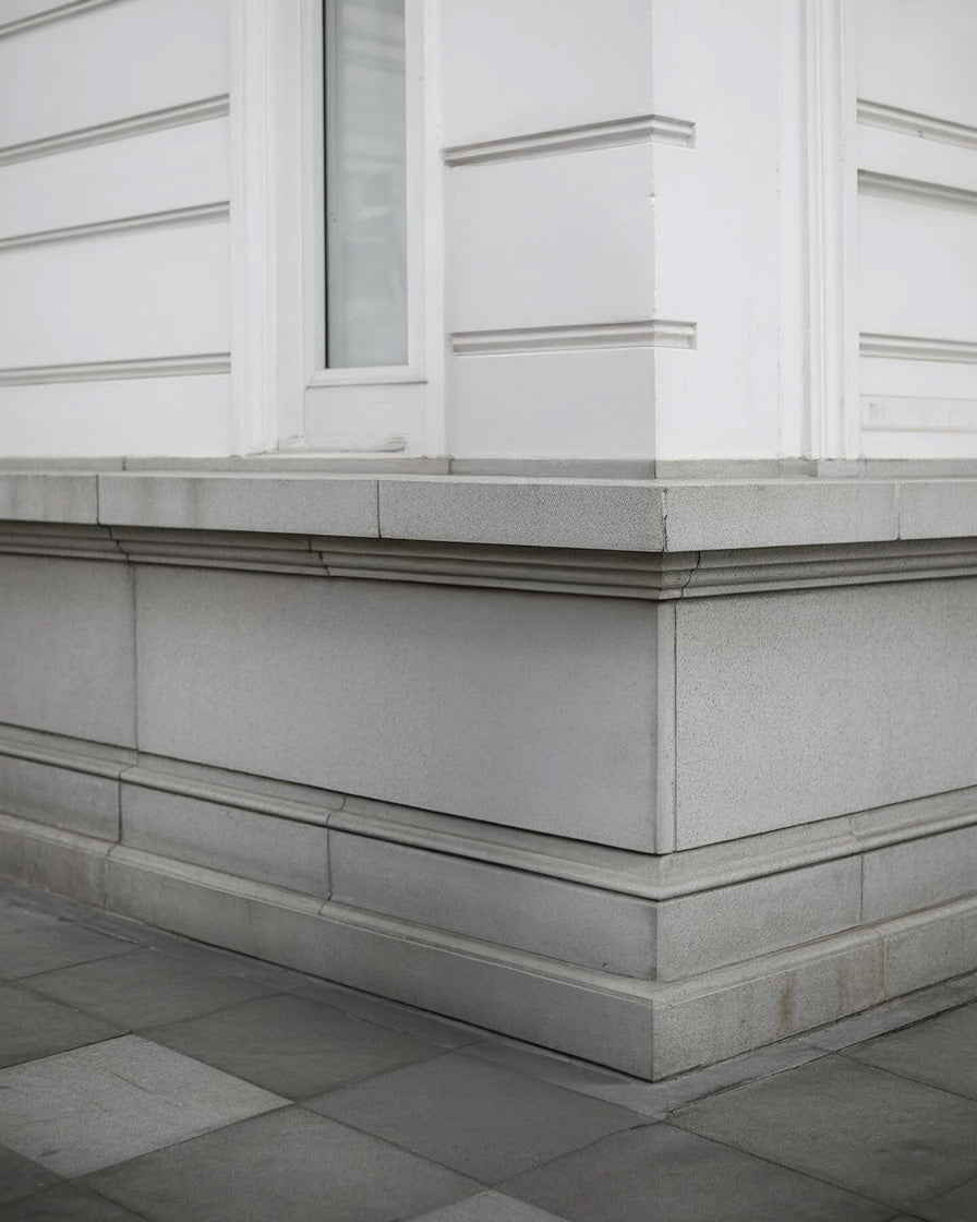 Elegant stone building corner with white trim and molding