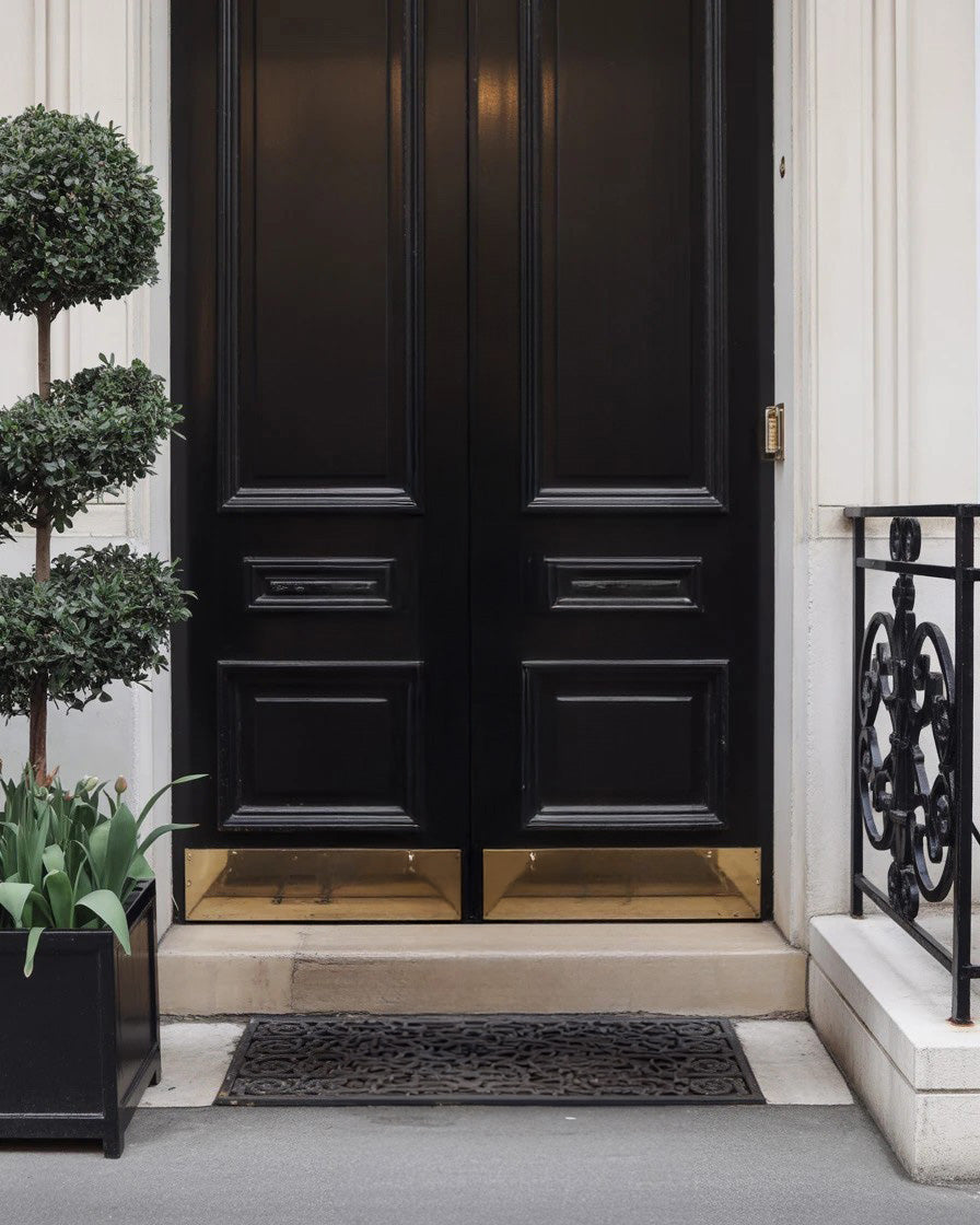 Elegant black double door with gold trim and railing