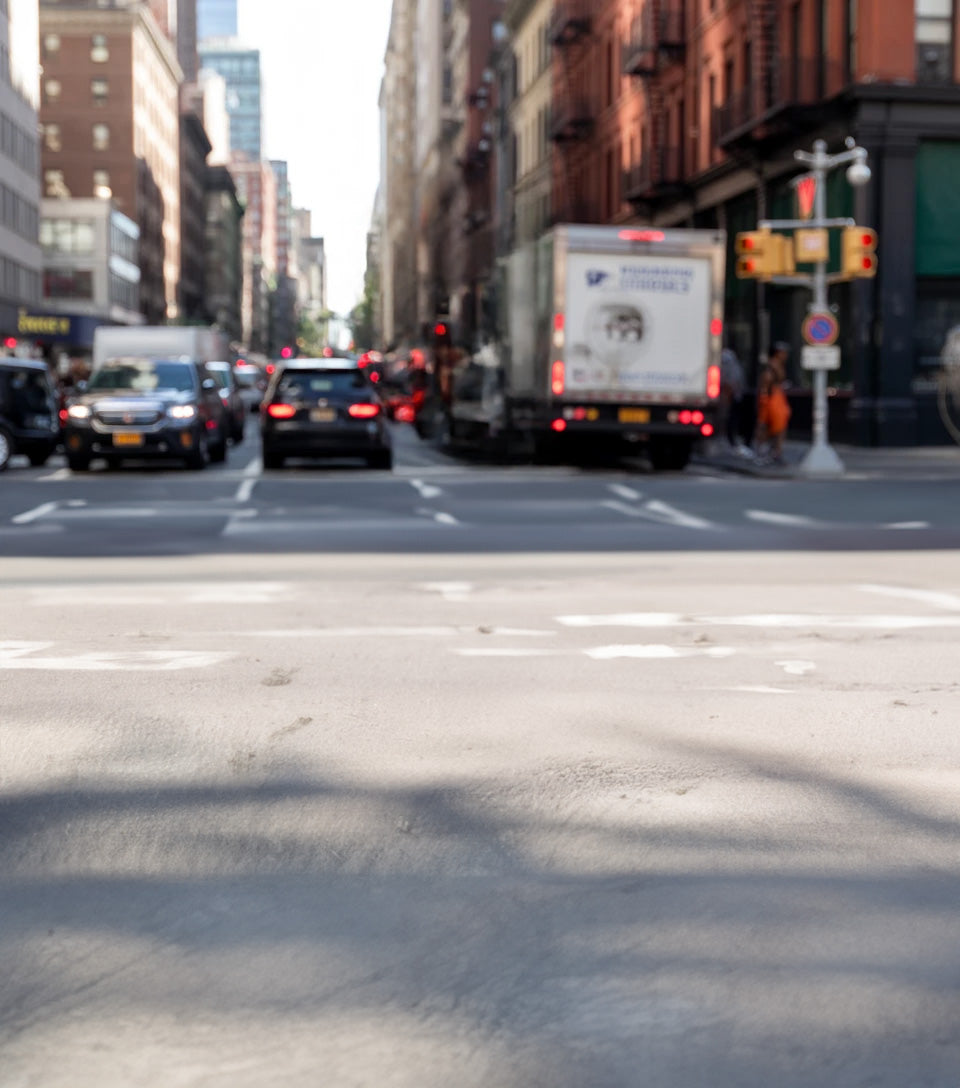 Busy urban street with cars, buildings, and traffic lights