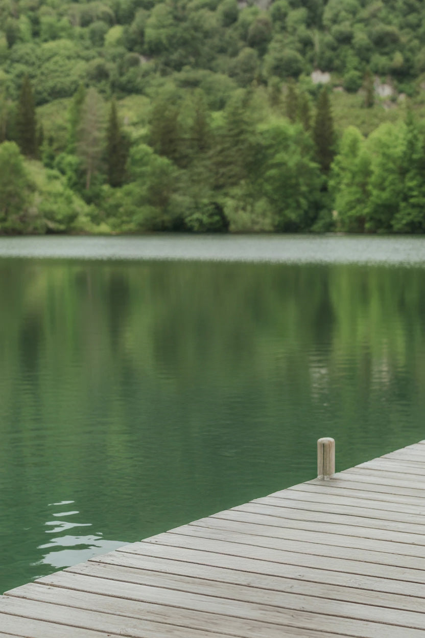Tranquil emerald lake surrounded by lush green forest.