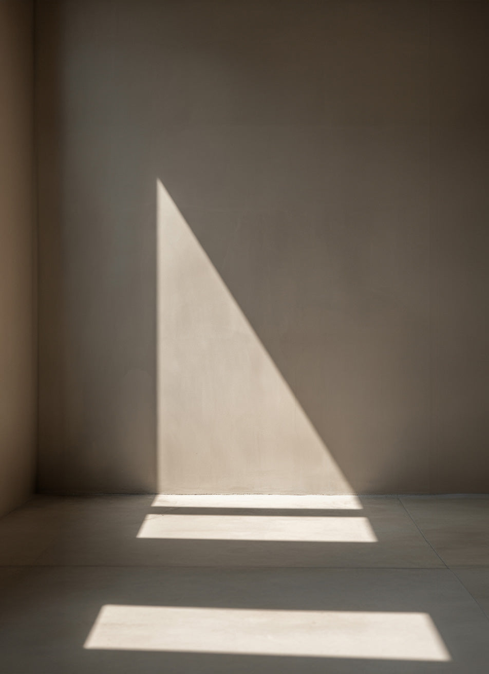 Minimalist interior wall with sunlight casting sharp shadows