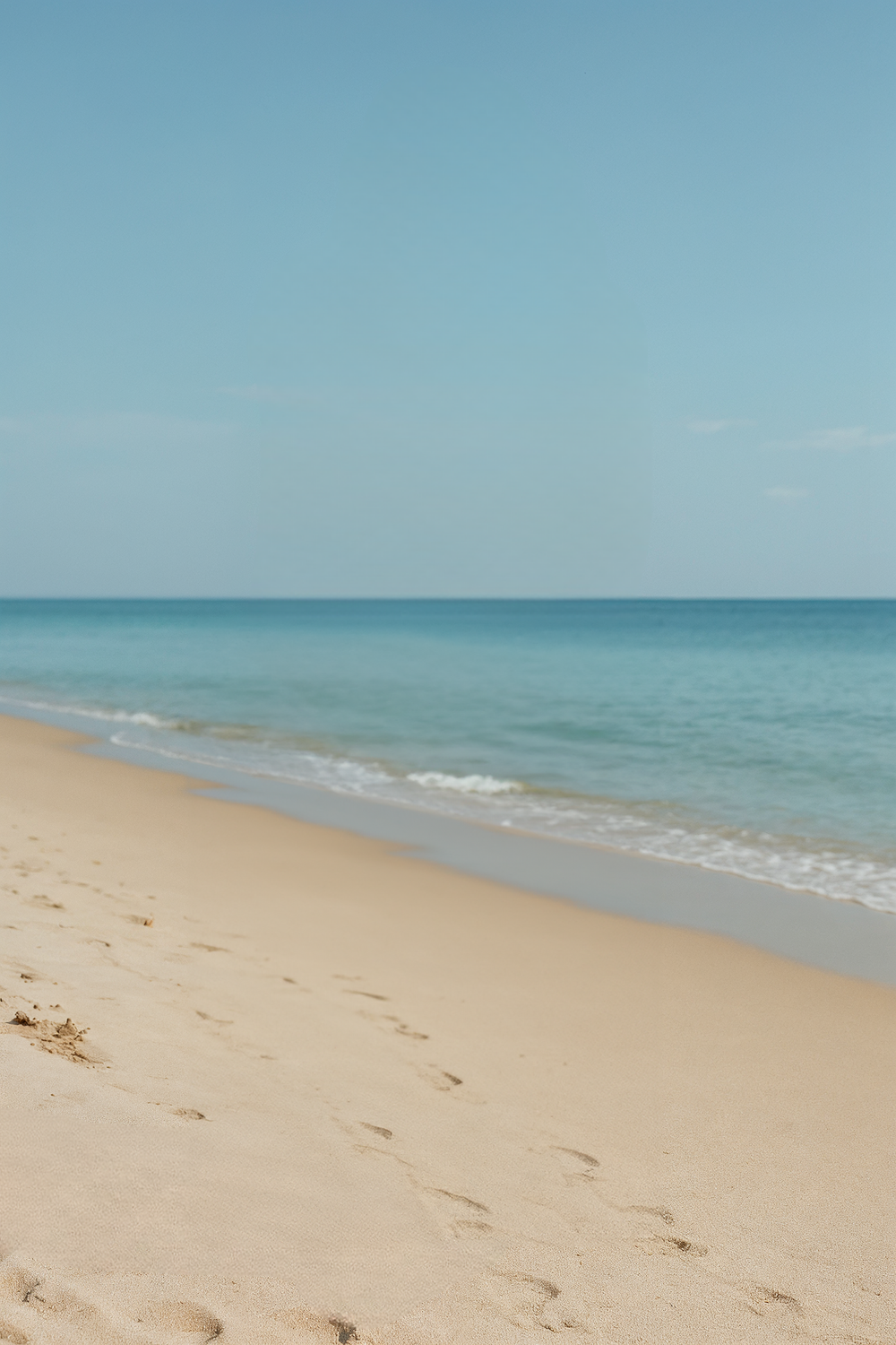 Clear blue sky and calm ocean waves on beach