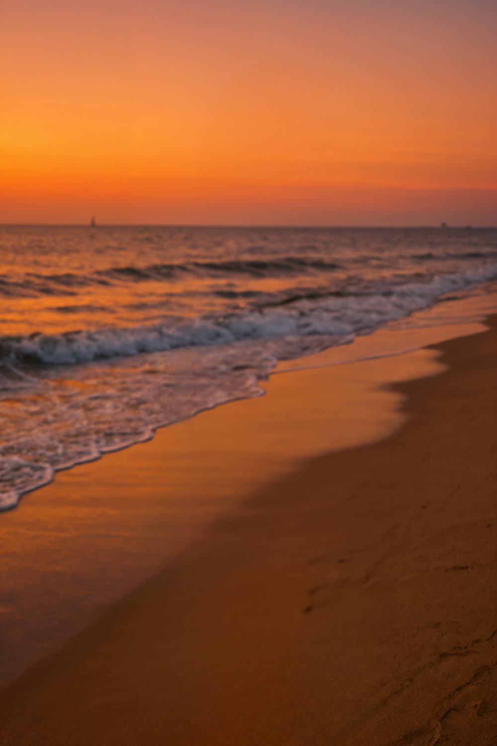 Vibrant sunset over ocean waves and sandy shoreline