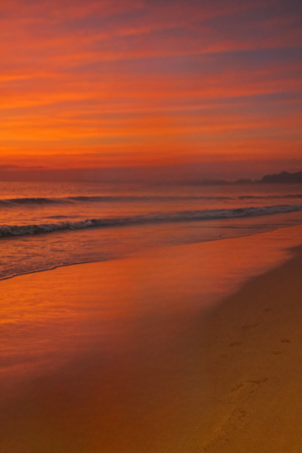 Vibrant sunset sky over calm ocean shoreline scene