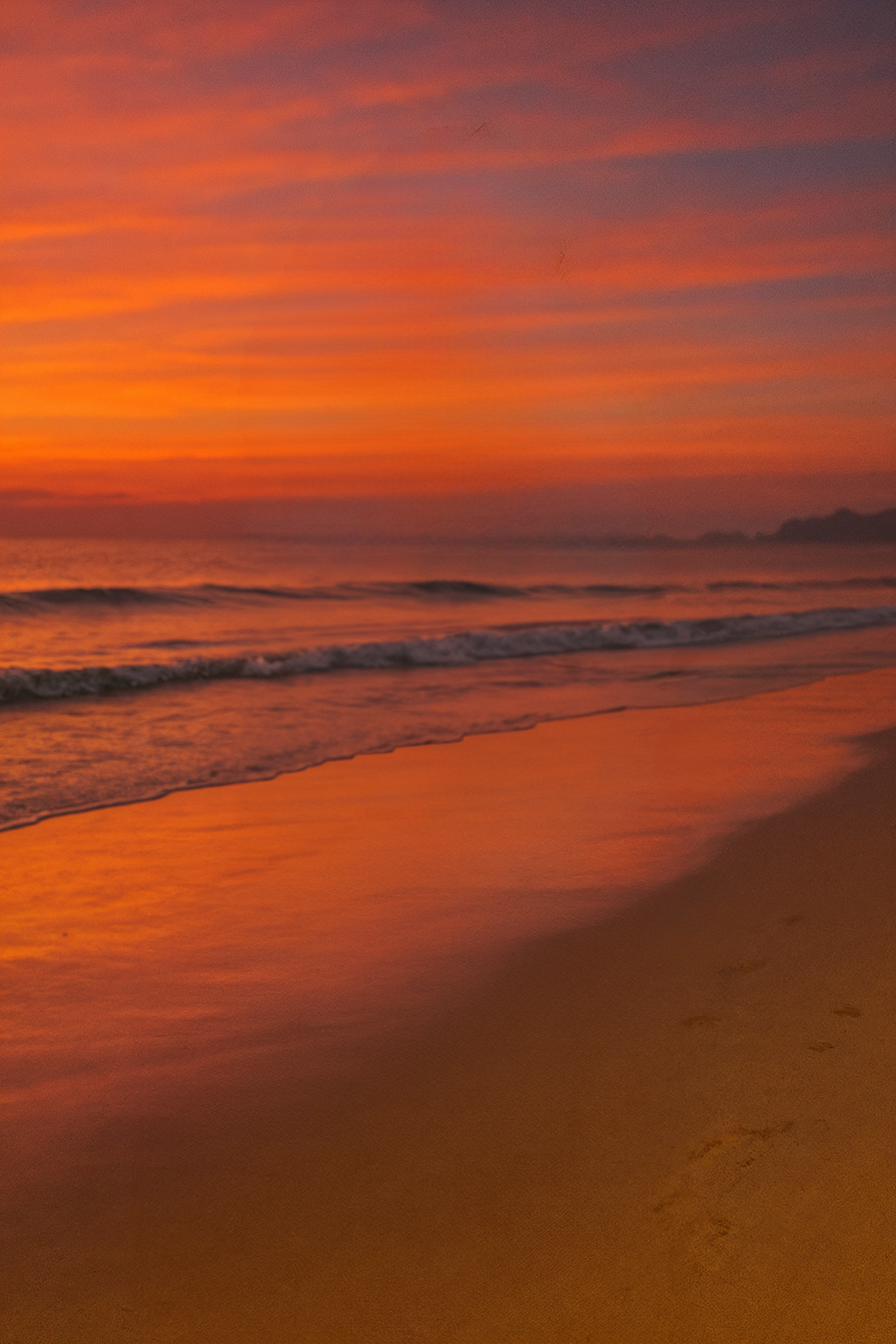 Vibrant beach sunset with waves and glowing sky