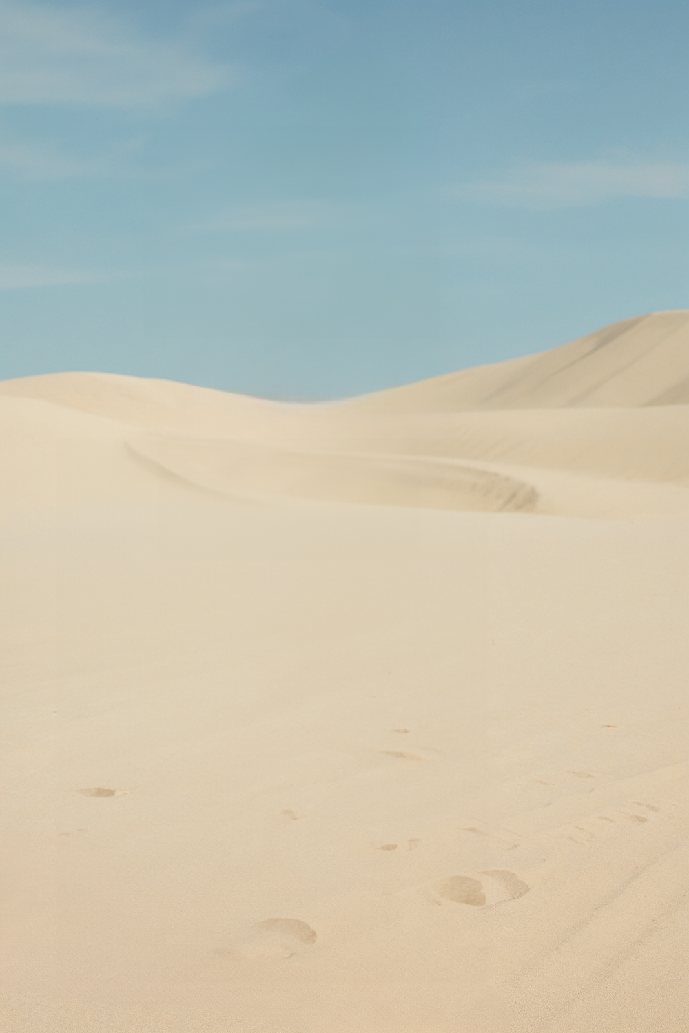 Vast sandy desert landscape beneath a clear blue sky
