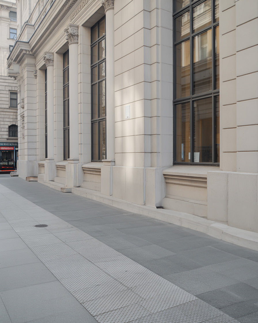 Stone building façade with tall windows on a city street