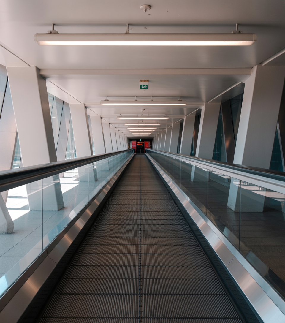 Sleek futuristic walkway with glass railings and strong geometric structural lines