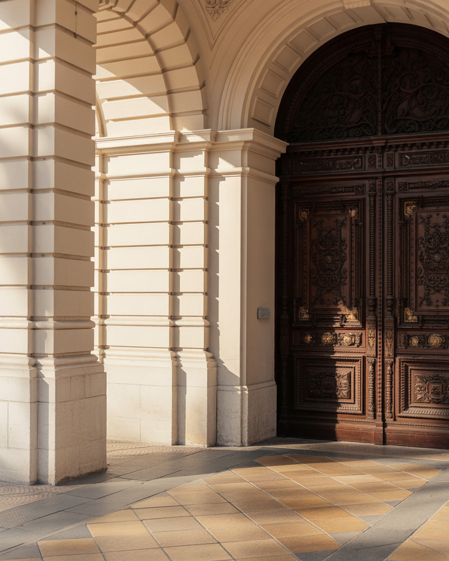 Historic ornate wooden door framed by cream stone arches and pillars