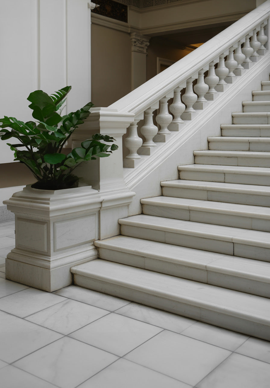 Elegant white marble staircase with classic balustrade and indoor architectural detailing