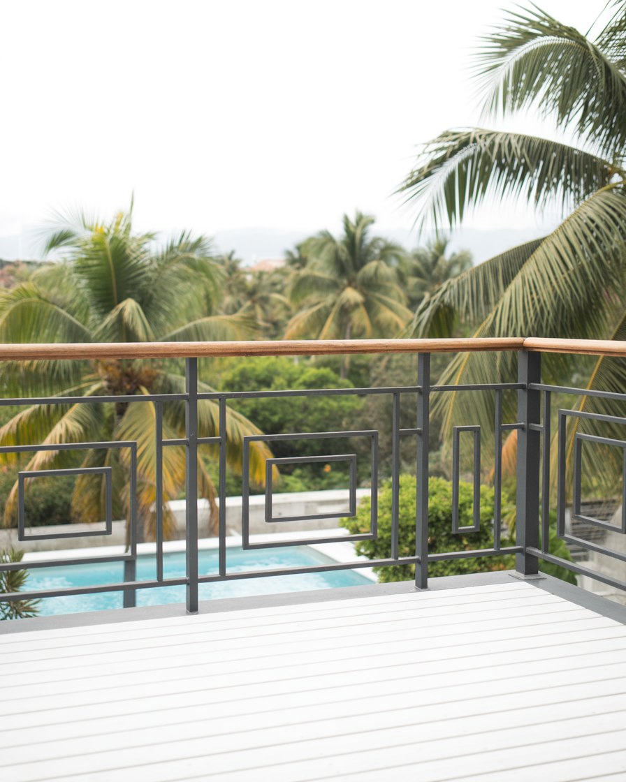 Tropical balcony overlooking palms and tranquil blue pool