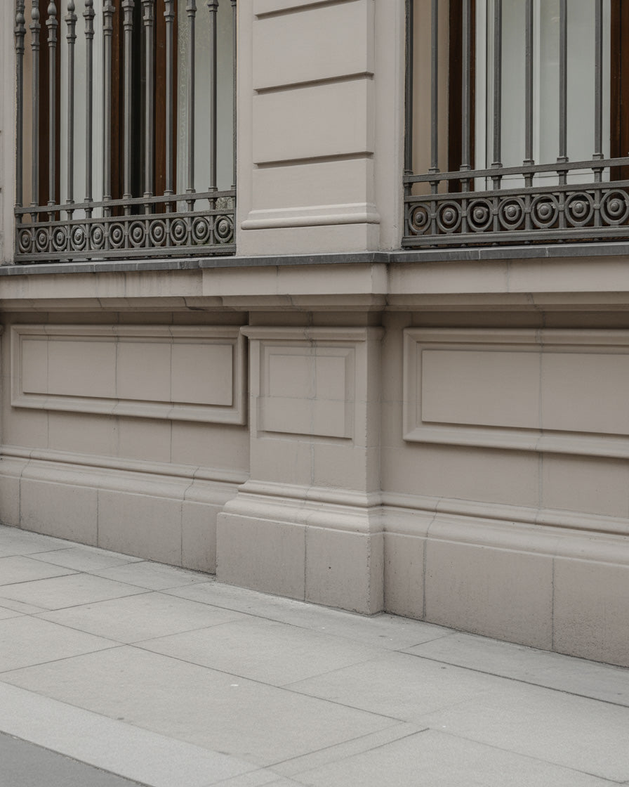 Elegant beige stone façade with ornate iron window railings