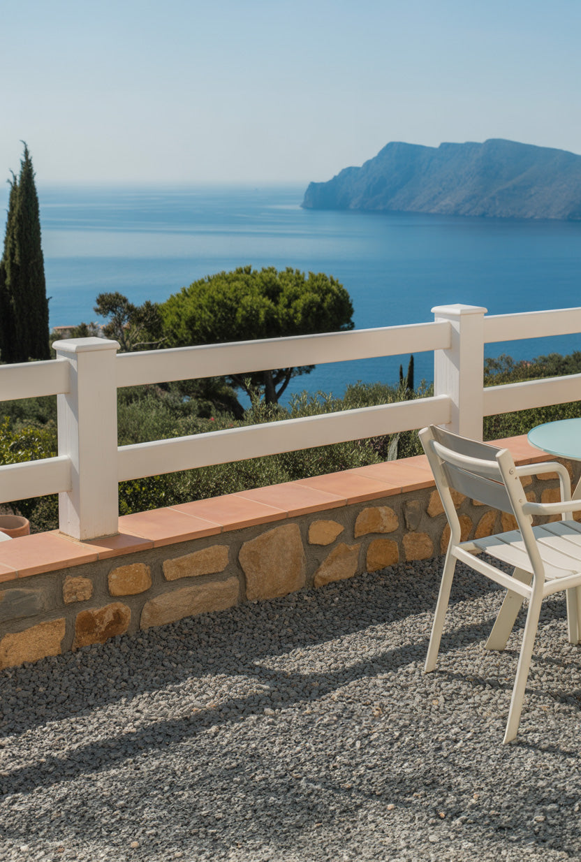 Sunlit coastal terrace overlooking calm blue sea and cliffs