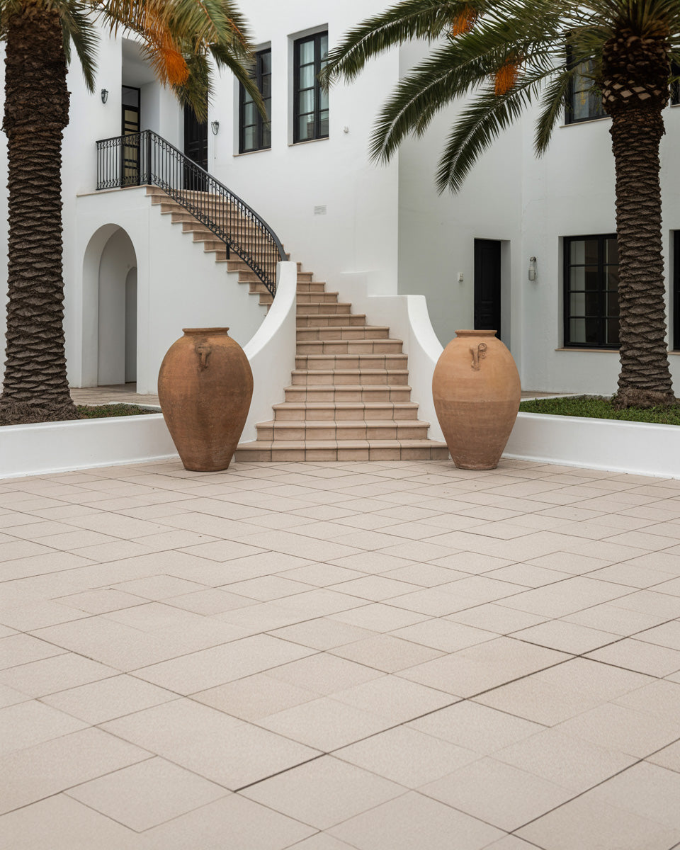 White Mediterranean villa courtyard with curved staircase and palm trees